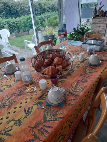 Primelin的住宿－Maison Entre Terre et Mer，上面有一篮牛角面包的桌子