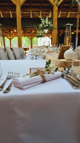 a table with a white table cloth with forks and knives at Tailor Hotel Sport & Conference in Morąg