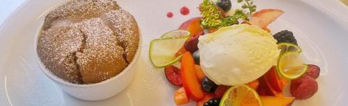a white plate of food with a sandwich and vegetables at Hotel Klammwirt in Feldthurns