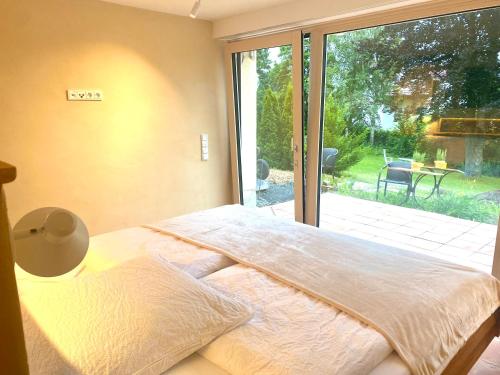 ein Schlafzimmer mit einem Bett und einem großen Fenster in der Unterkunft Die Finca in Hünfeld