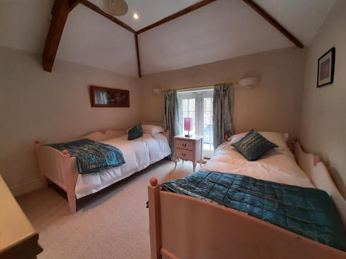 1 dormitorio con 2 camas y ventana en Coach House, Minting. en Horncastle