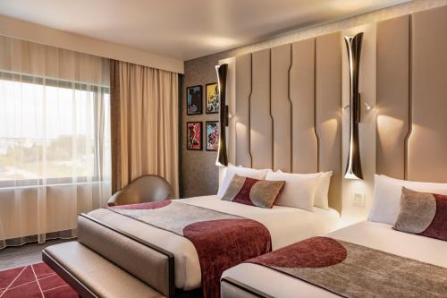 Habitación de hotel con 2 camas y ventana en Disney Hotel New York - The Art of Marvel, en Chessy
