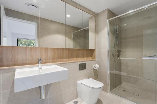 a bathroom with a toilet and a sink and a shower at Pinnacle on the Park in Gold Coast