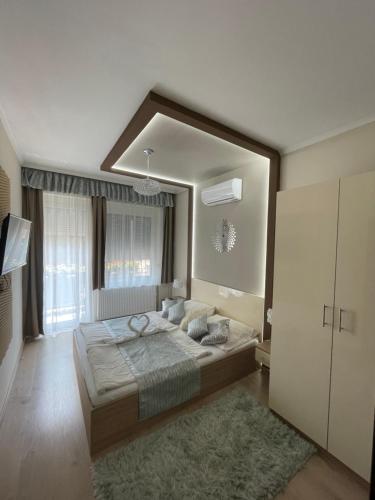 1 dormitorio con 1 cama grande y espejo grande en Melior Szálló, en Eger