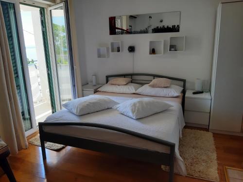 a bedroom with two beds with white sheets and pillows at Apartments Anita in Gradac