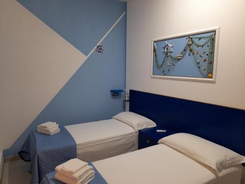 a room with two beds and a blue wall at Ely Sea in Belvedere Marittimo