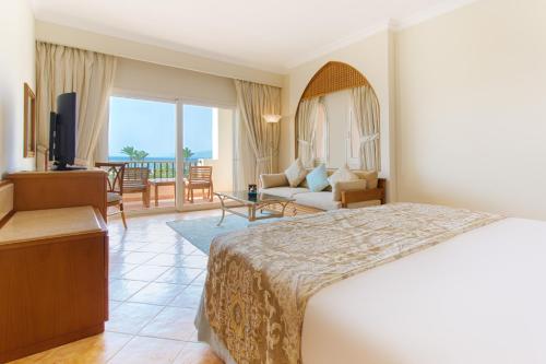 a hotel room with a bed and a living room at Kempinski Hotel Soma Bay in Hurghada