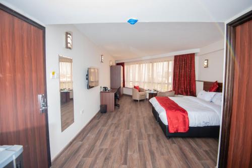 a hotel room with a bed and a desk at The Crossroads Hotel, Westlands in Nairobi