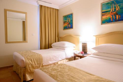 A bed or beds in a room at Mövenpick Al Nawras Jeddah - Family Resort
