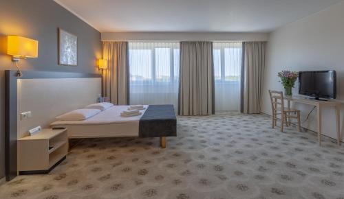 a hotel room with a bed and a television at Aurora Hotel Klaipeda in Klaipėda