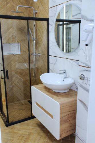 a bathroom with a sink and a shower at Apartamenty na skraju lasu in Ustka