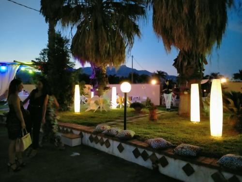 a group of people standing in a park with lights at Villa Laura Apartment in Giardini Naxos