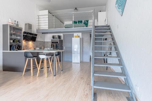 un salon avec un escalier menant à une mezzanine dans l'établissement Le Cocon Loft Metz Luxembourg Un-Séjour-à-Part, à Amnéville