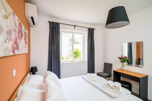 a bedroom with a bed and a desk and a window at Nona's Paradise Apartment - Free parking in Zaton