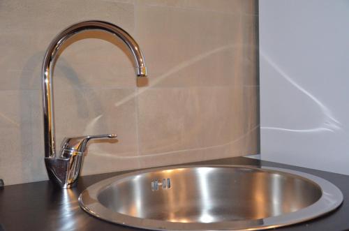 un lavandino in acciaio inossidabile con rubinetto su un bancone di Dei Balzi apartments a Conversano