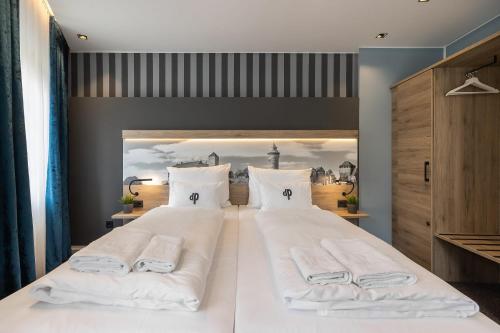 a large white bed with two white towels on it at Oldtown Studios by dasPaul in Nuremberg