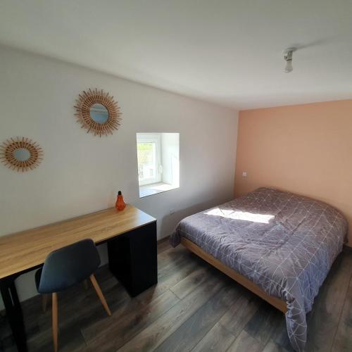 une chambre avec un lit, un bureau et un miroir dans l'établissement La Tour de l'Hirondelle, à Lussas