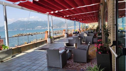 a patio with chairs and a view of the water at Hotel Centro Congressi Polo Nautico in Salerno