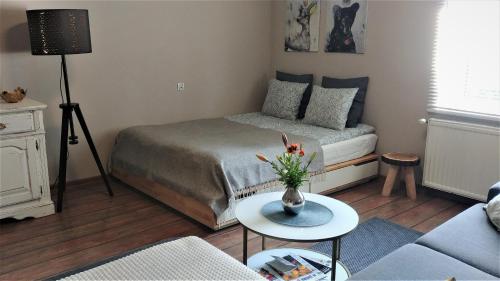 a bedroom with a bed and a table with a vase of flowers at Apartamenty NOVA na Krakowskiej No 1 in Bielsko-Biala