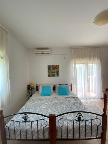 1 dormitorio con 1 cama grande con almohadas azules en Apartments Villa Andjela en Budva