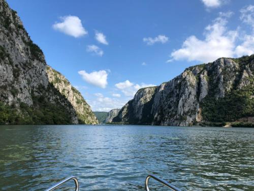 a boat on a lake in front of mountains at CASA 9 - villa & spa in Eşelniţa