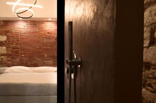 uma porta para um quarto com uma cama e uma parede de tijolos em Covo del Carbonaro em Ascoli Piceno