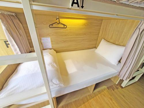 a small room with a white bed in a caravan at Paper Plane Hostel in Kaohsiung
