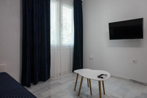 - un salon avec une table, une télévision et un canapé dans l'établissement AZ modern studio, à Vólos