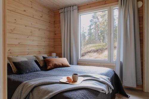 a bedroom with a bed and a large window at Villa Korppi in Jorvas