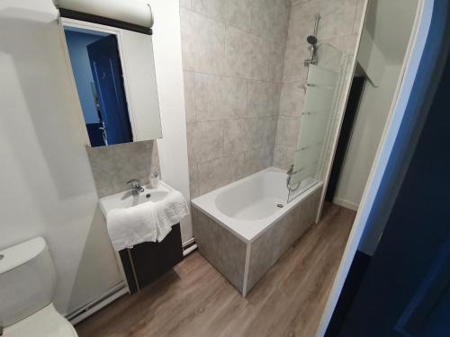 a bathroom with a sink and a tub and a toilet at Le Flobart in Le Portel