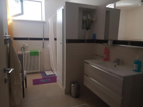 La salle de bains est pourvue d'un lavabo, d'une baignoire et d'une douche. dans l'établissement Appartamento Aloha, à Roseto degli Abruzzi