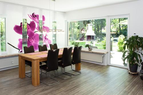 a dining room with a wooden table and black chairs at Lüneburger Heide - Ferienwohnung am Höpen in Schneverdingen