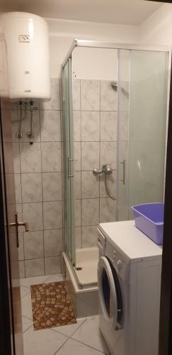 a bathroom with a shower and a washing machine at Rooms Raulo in Split