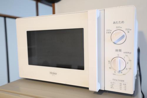 a microwave oven sitting on top of a counter at Fukuoka Condominium in Fukuoka