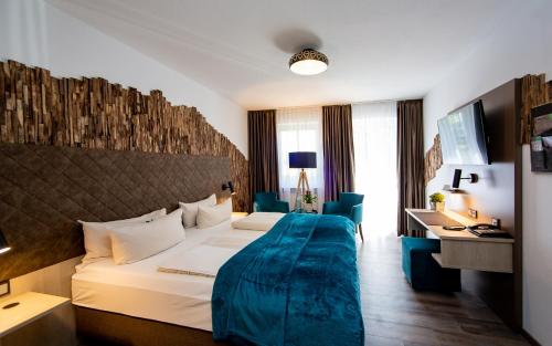 a hotel room with two beds and a desk at Arcus Hotel München Messe in Feldkirchen