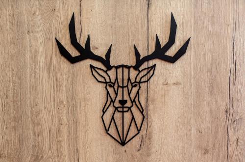 a metal wall art of a deer head on a wooden wall at Arcus Hotel München Messe in Feldkirchen