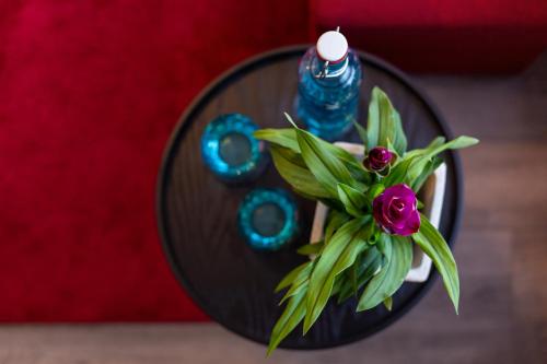 a black table with a blue bottle and a flower at Arcus Hotel München Messe in Feldkirchen