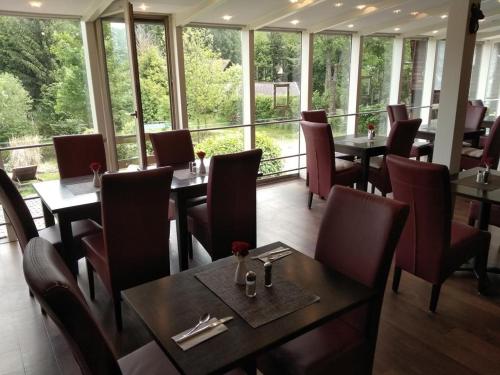 un restaurante con mesas, sillas y ventanas en Apartment Christopherhof 11, Grafenwiesen, en Grafenwiesen