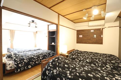 a bedroom with two beds and a window at Fukuoka Condominium in Fukuoka