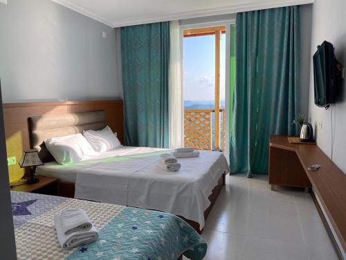 a hotel room with two beds and a window at Green Hills Batumi in Batumi