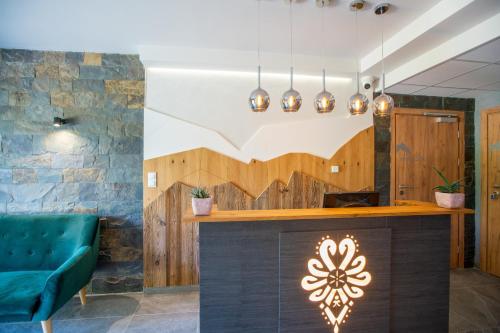 a lobby with a bar with a green couch at Aparthotel Pod Stokiem z sauną i jacuzzi - szczyrkapartamenty in Szczyrk