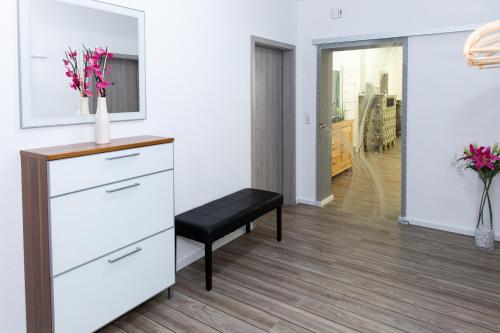 a living room with a white dresser and a black stool at Lüneburger Heide - Ferienwohnung am Höpen in Schneverdingen