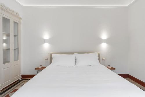 a bedroom with a large white bed with two lamps at PALAZZO FRANGIPANE in Salve