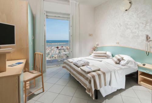 a bedroom with a bed and a large window at Strand Hotel in Gabicce Mare