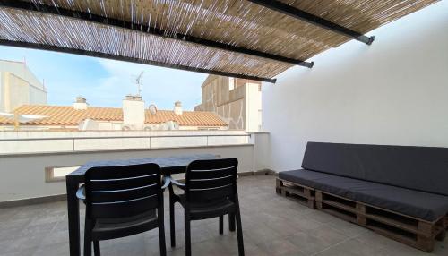 een tafel en stoelen in een kamer met uitzicht bij Apartaments l'Escala Centre in L'Escala