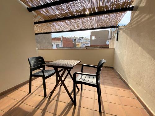 een tafel en 2 stoelen op een balkon bij Apartaments l'Escala Centre in L'Escala