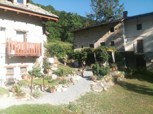 a garden in front of a house with potted plants at B&B L'Abric - centro storico di Limonetto in Limone Piemonte