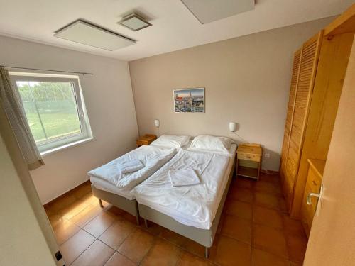 una camera con un letto bianco e una finestra di Holiday Village Senec a Senec