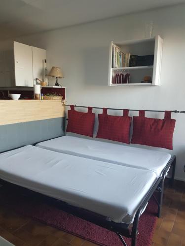 1 cama con almohadas rojas en una habitación en Gentiane, en Les Orres