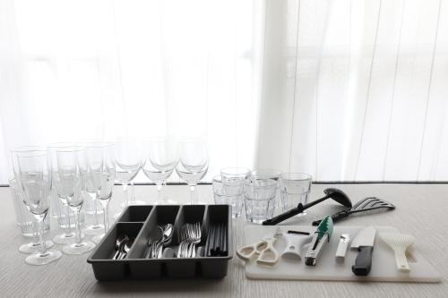 a kitchen counter with wine glasses and a sink at Fukuoka Condominium in Fukuoka